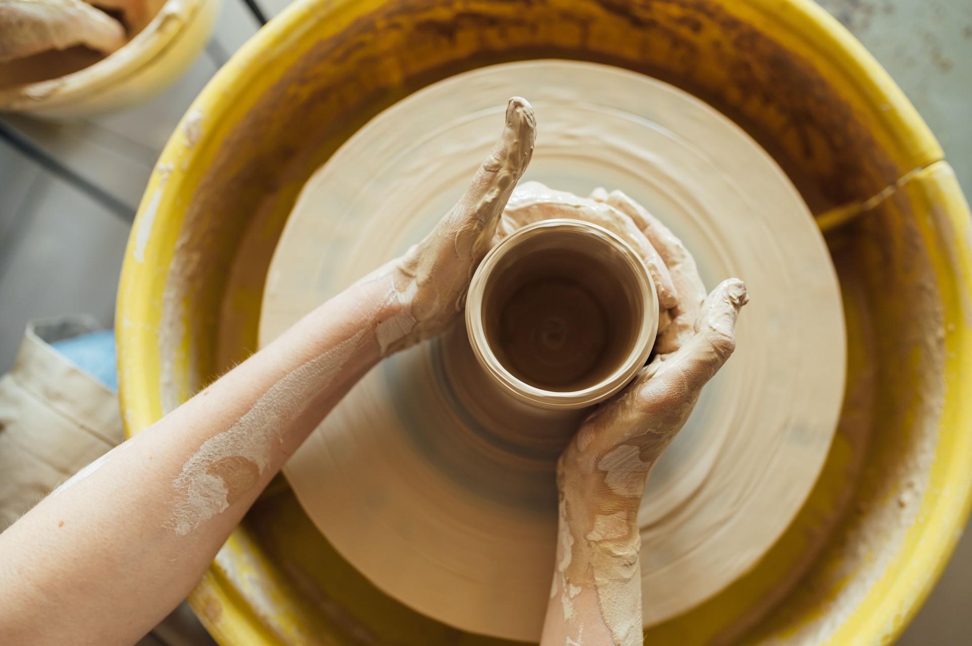 Hands of a potter. Potter making ceramic pot on the pottery wheel