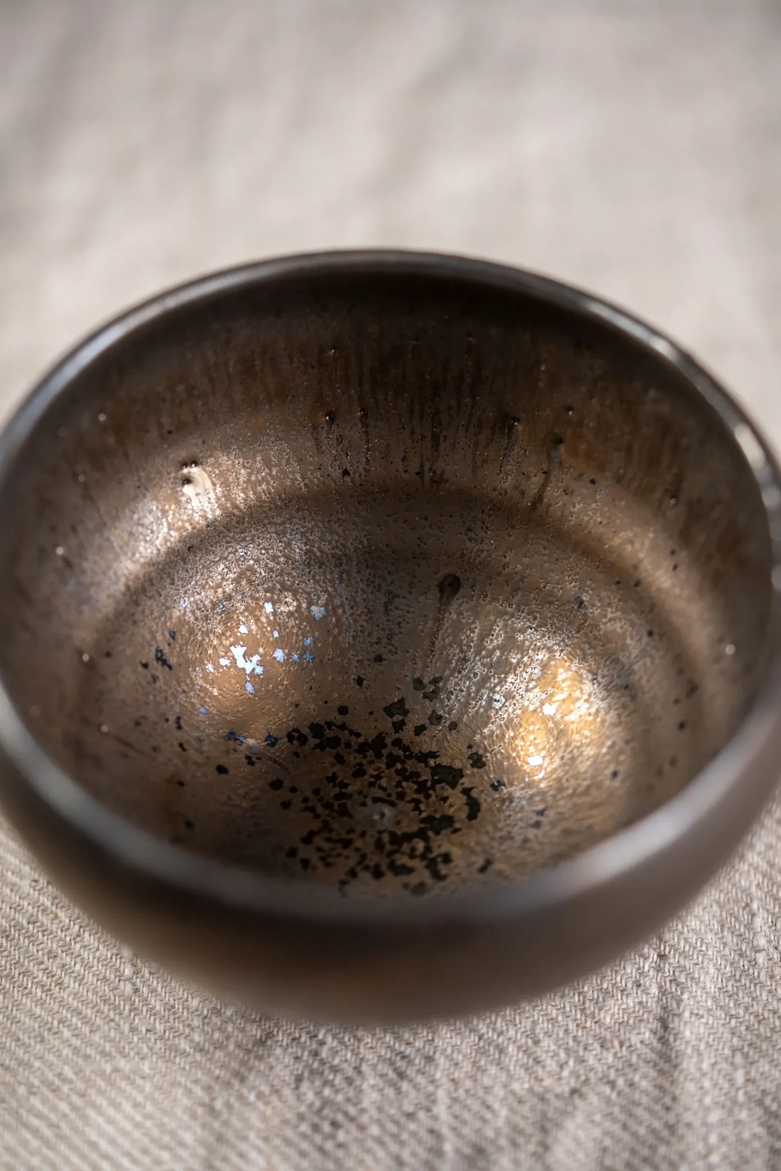 A bronze-glazed ceramic bowl, seen from above