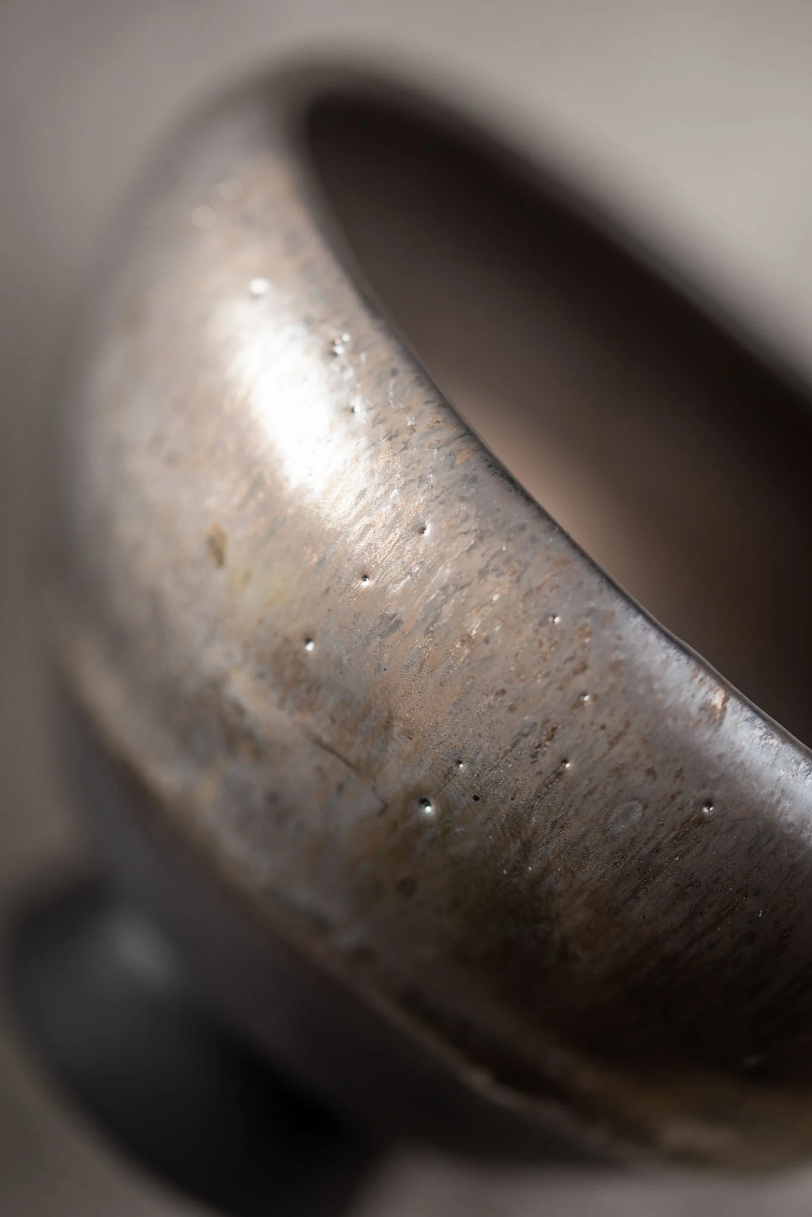The rim and wall of a glazed ceramic piece